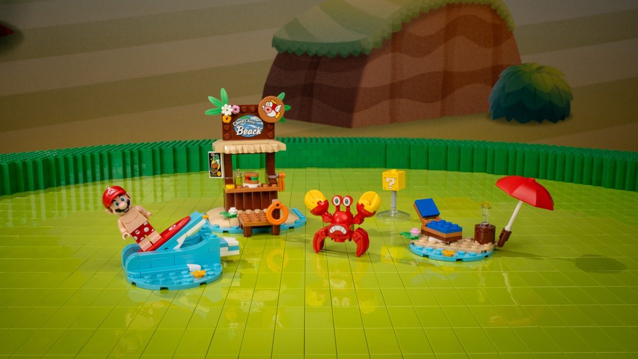 LEGO Super Mario Beach set with Mario minifigure, red crab, beach hut, pool, and umbrella on green baseplate.