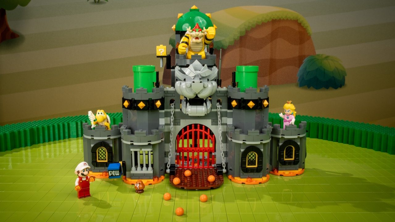 LEGO Super Mario castle set with Bowser figure, Princess Peach, Toad, and minifigures on green baseplate.