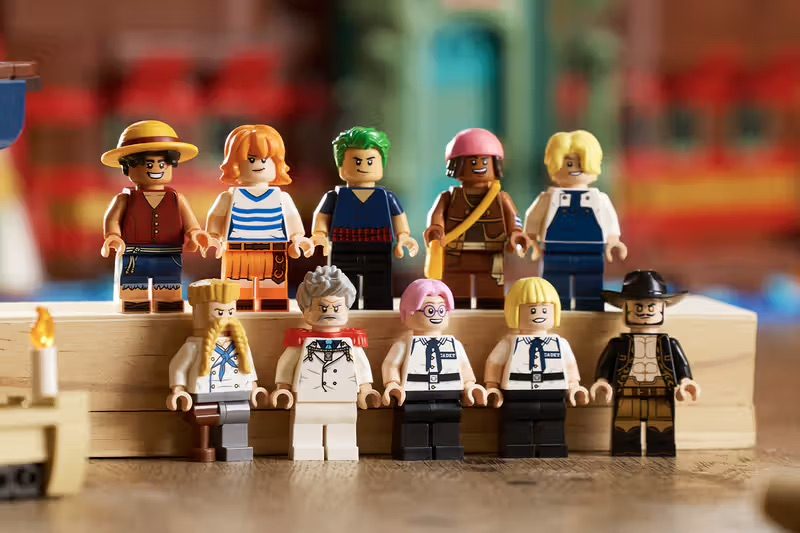 Ten LEGO minifigures from One Piece displayed on wooden platforms against a blurred colorful background.