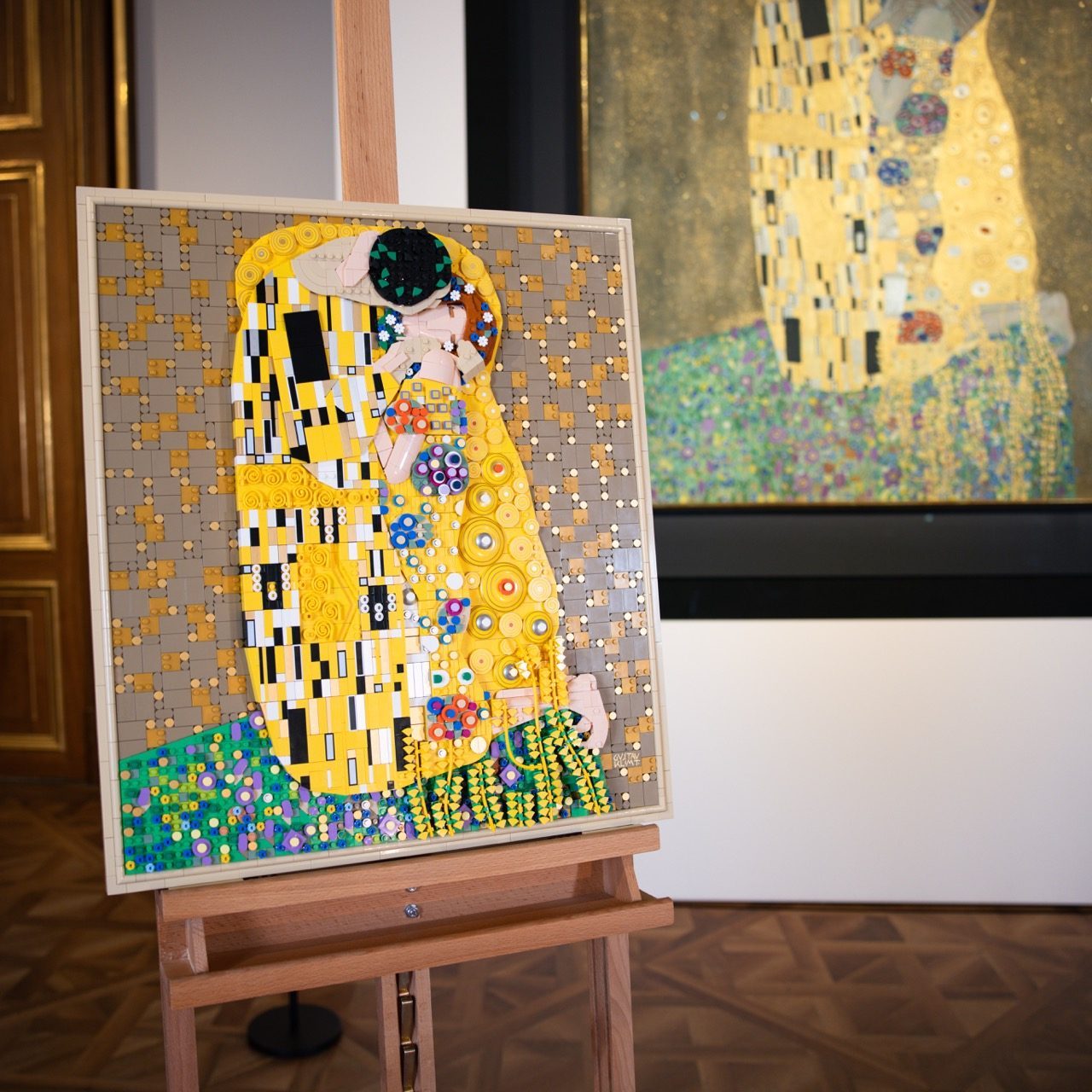 LEGO Art Gustav Klimt "The Kiss" set displayed on wooden easel in gallery setting.