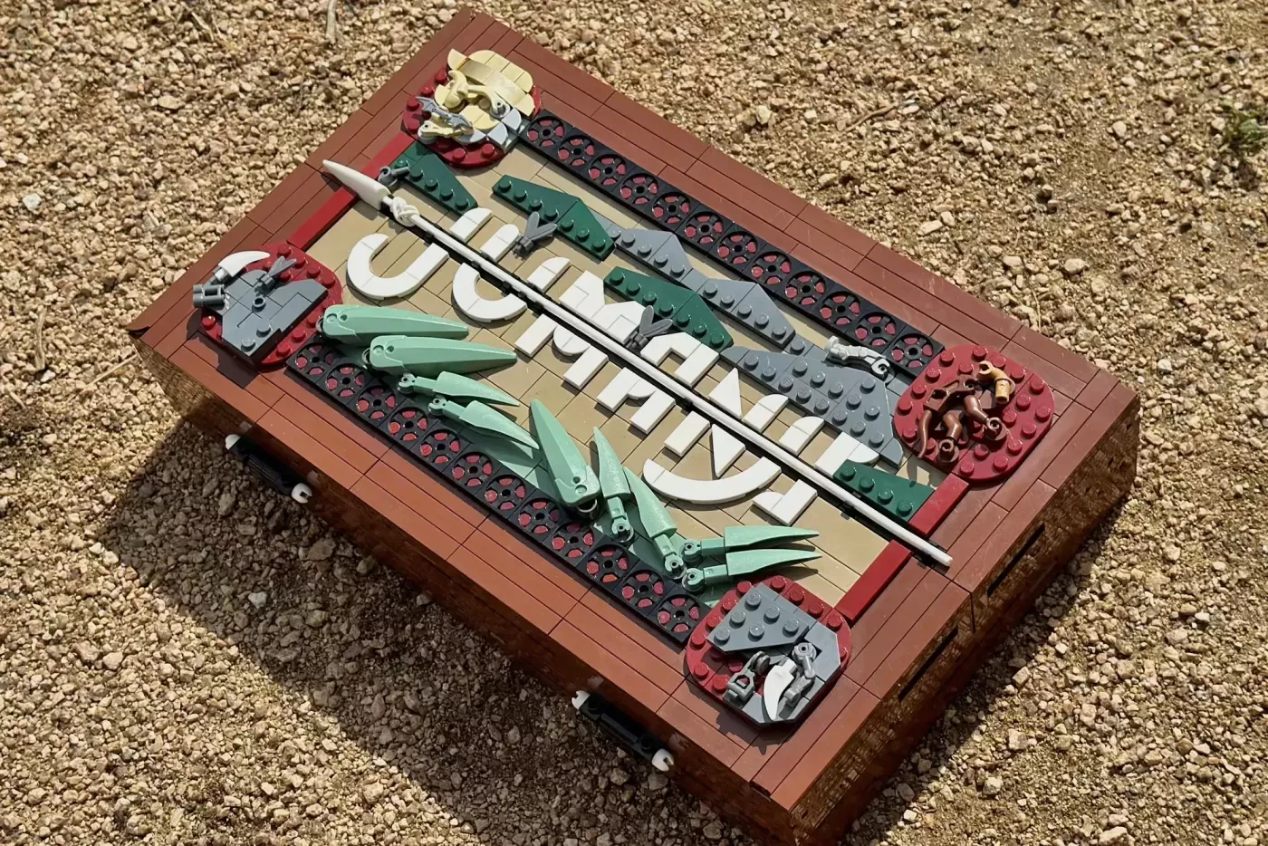 LEGO Jumanji board game set displayed on sandy surface with green lever pieces and tan game board.