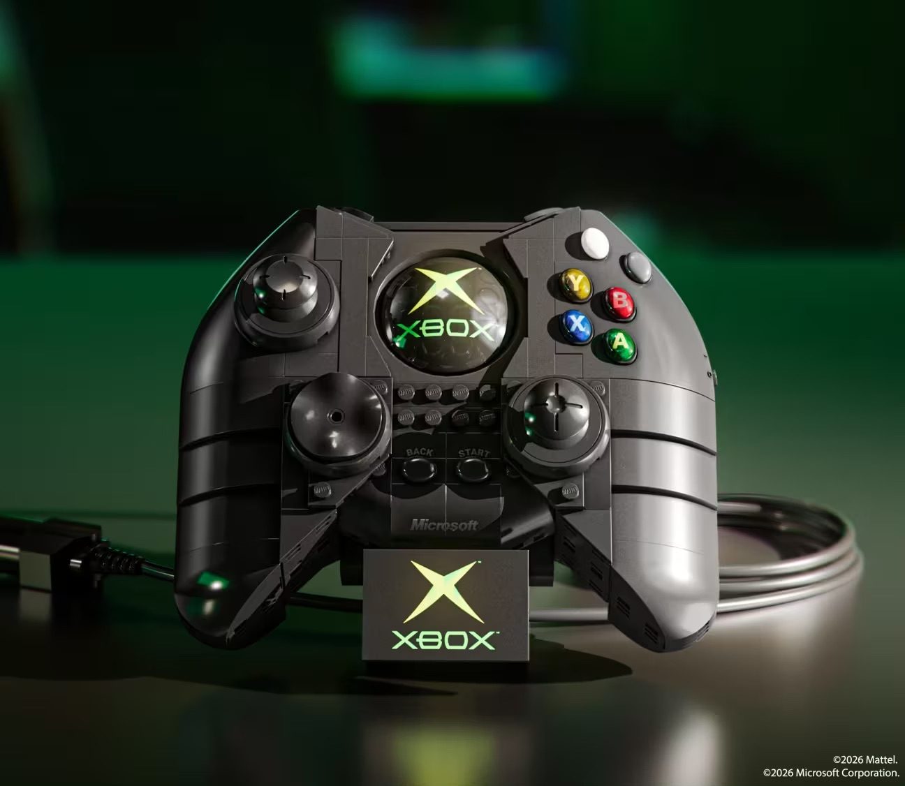 LEGO Xbox controller set displayed with illuminated X logo and colored buttons on green background.