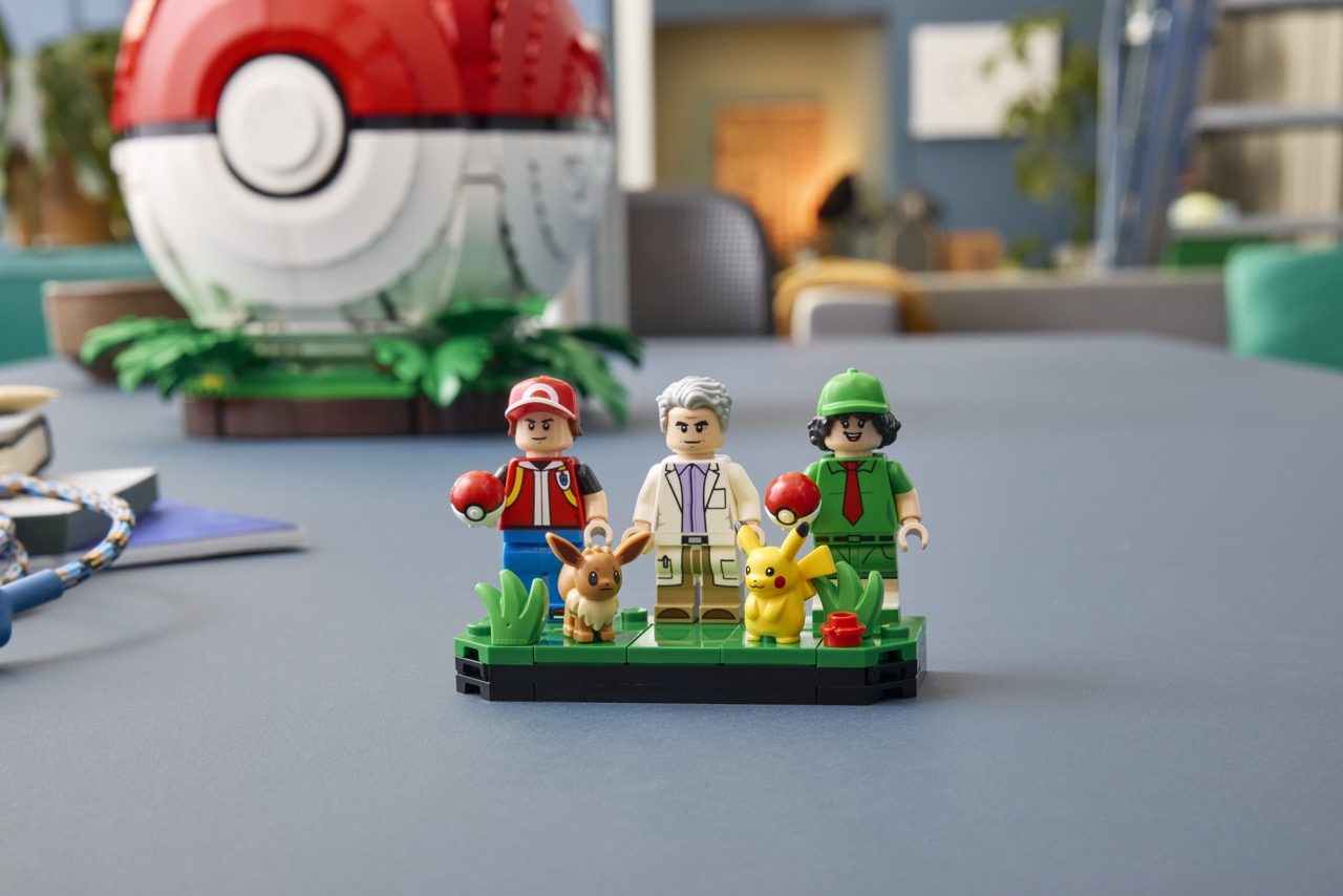 LEGO Pokémon set featuring three minifigures, Eevee and Pikachu figures on a green base, with a Poké Ball display in the b…