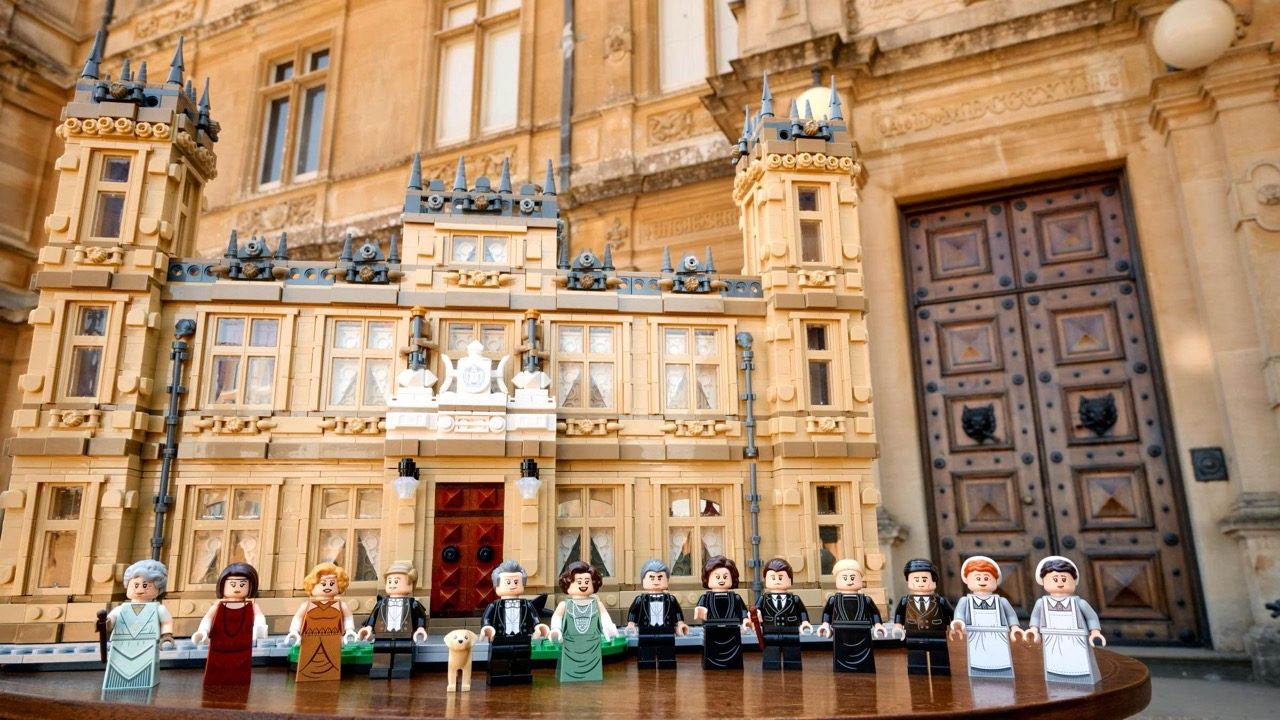 LEGO Downton Abbey set featuring Highclere Castle with minifigures displayed in front of the ornate brick facade.