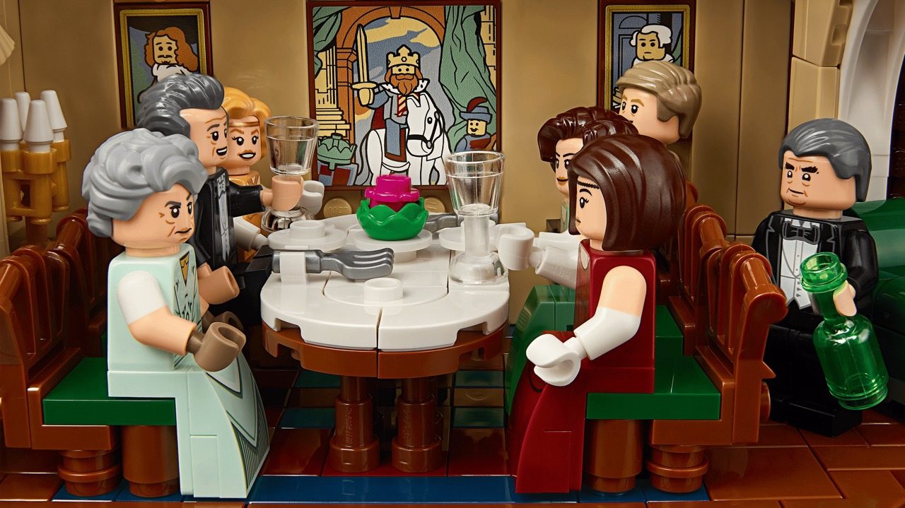LEGO Downton Abbey set featuring minifigures seated at dining table in elegant room with period artwork.