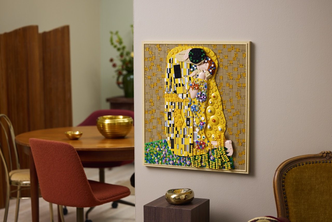LEGO Art Gustav Klimt "The Kiss" set displayed on wall in modern living room with gold accents.