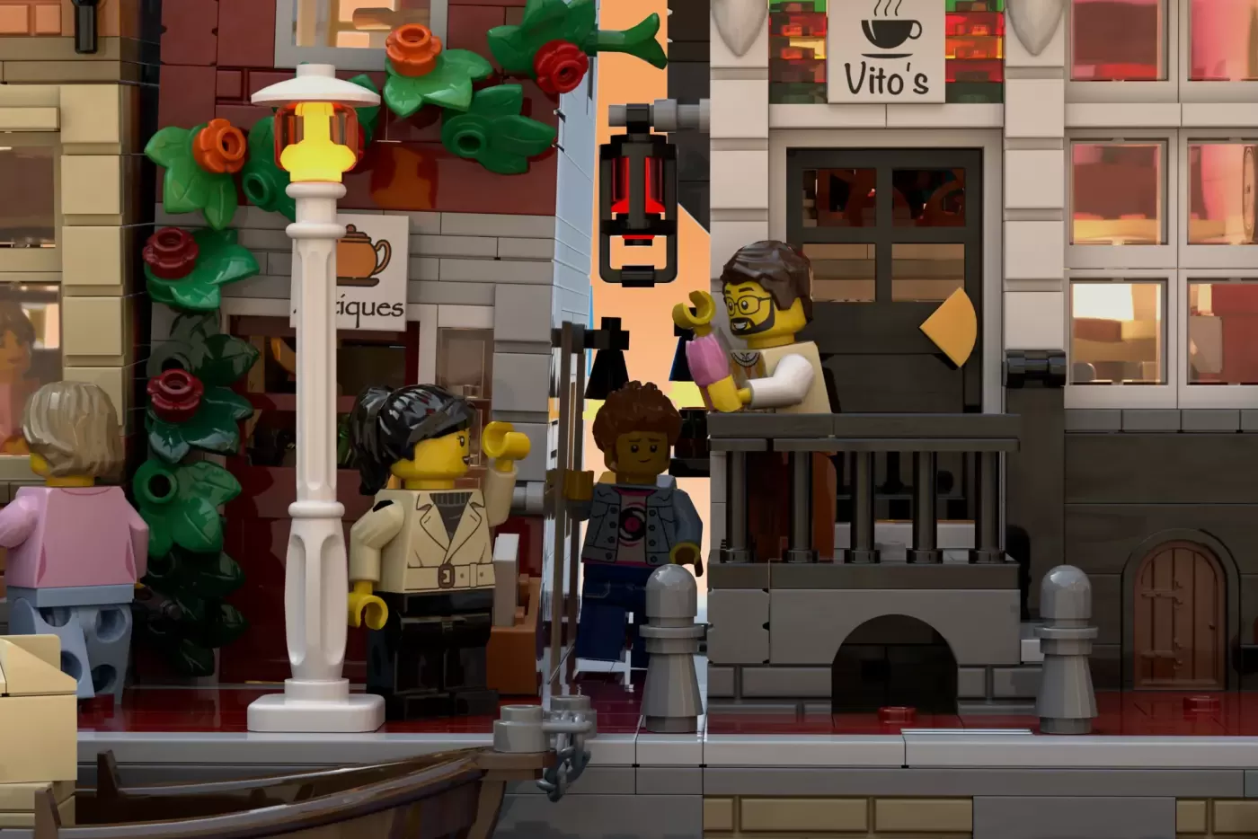 LEGO Amsterdam canal scene with minifigures, ornate lamppost, flowering vines, and Vito's café storefront.