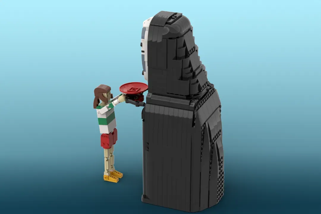 LEGO minifigure of Chihiro offering a red token to a tall black No-Face piggy bank structure against blue background.