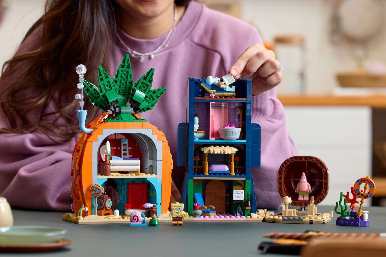 Person in purple shirt holding LEGO SpongeBob SquarePants Bikini Bottom set with colorful building structures and minifigu…