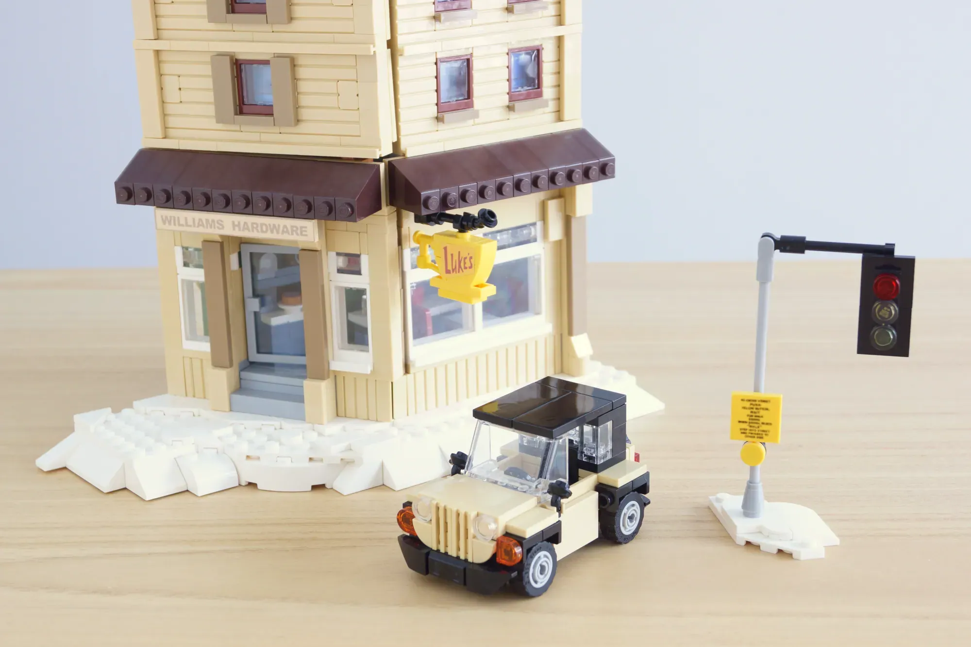 LEGO Stars Hollow set with Luke's Diner storefront, cream Jeep vehicle, traffic light, and snow piles.