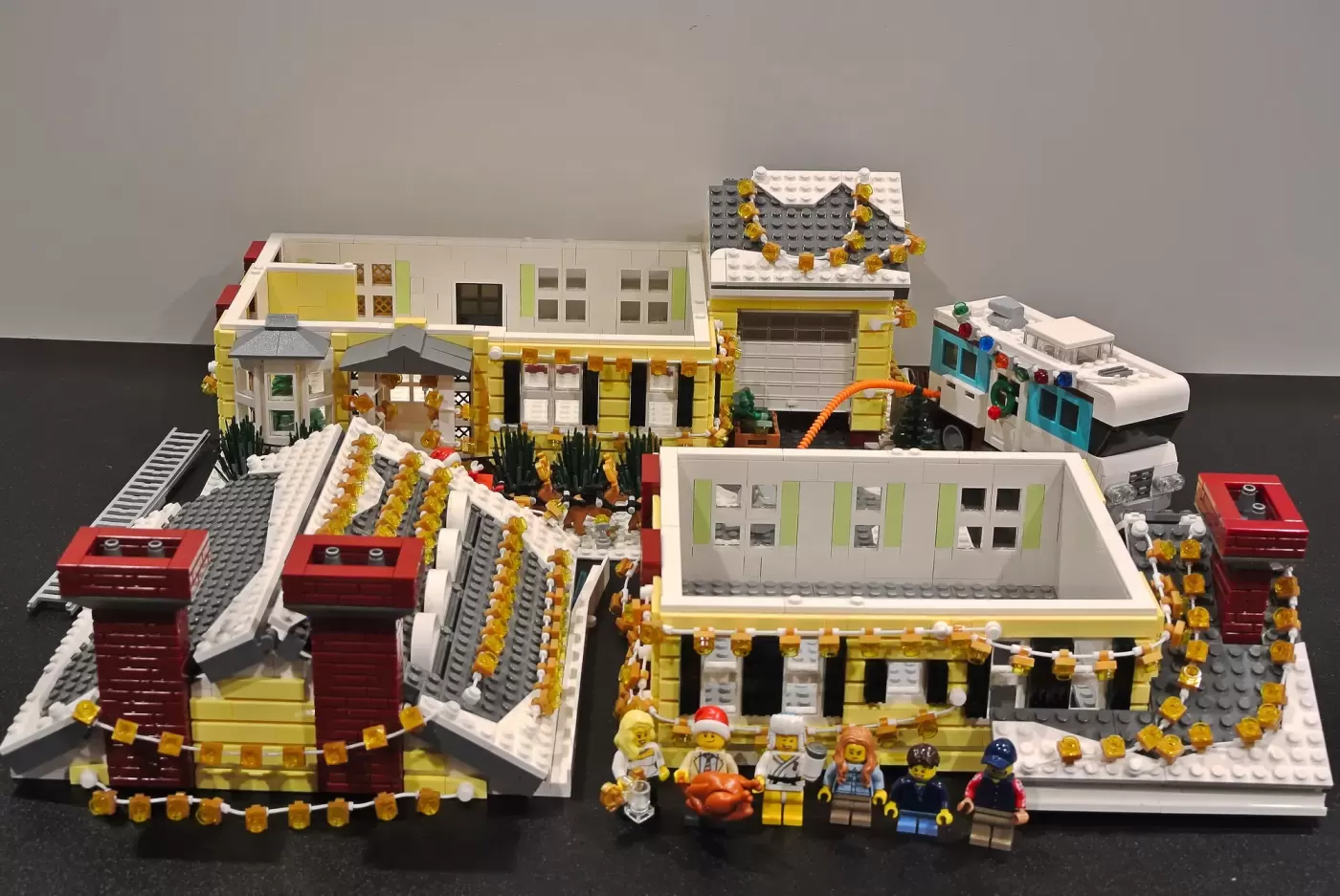LEGO Christmas Vacation Griswold House set with yellow mansion, red chimneys, decorated with gold garland, minifigures, an…