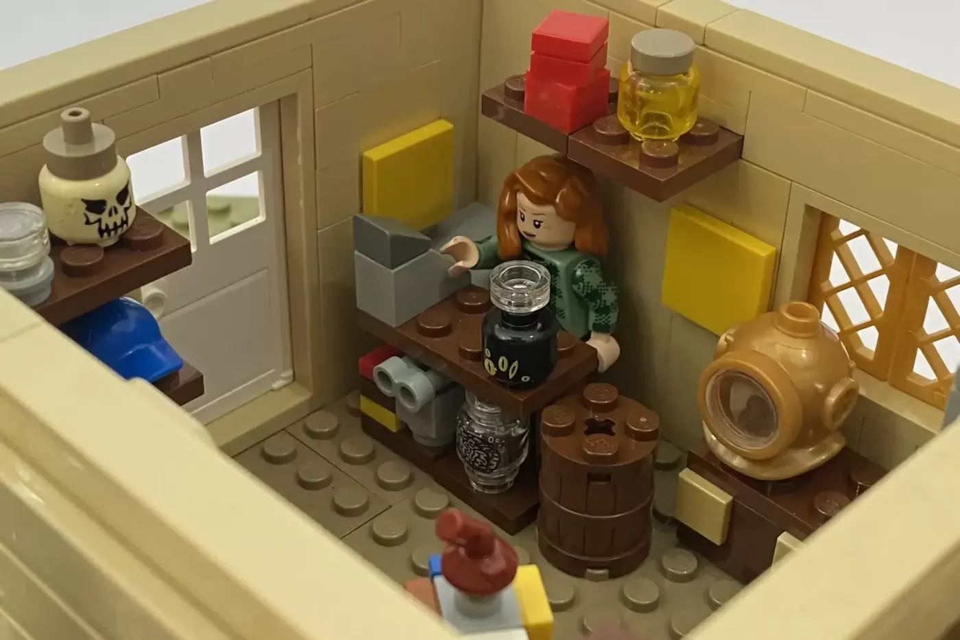 LEGO Gravity Falls Mystery Shack interior with minifigure, potion bottles, barrels, and mystical artifacts on display.