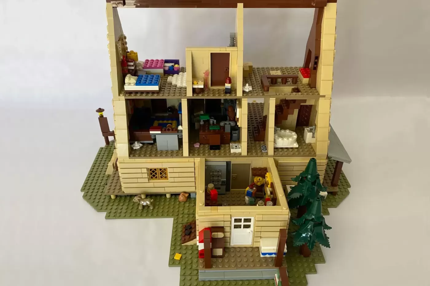 LEGO Mystery Shack dollhouse with multiple rooms, minifigures, Christmas tree, and detailed interior furnishings.