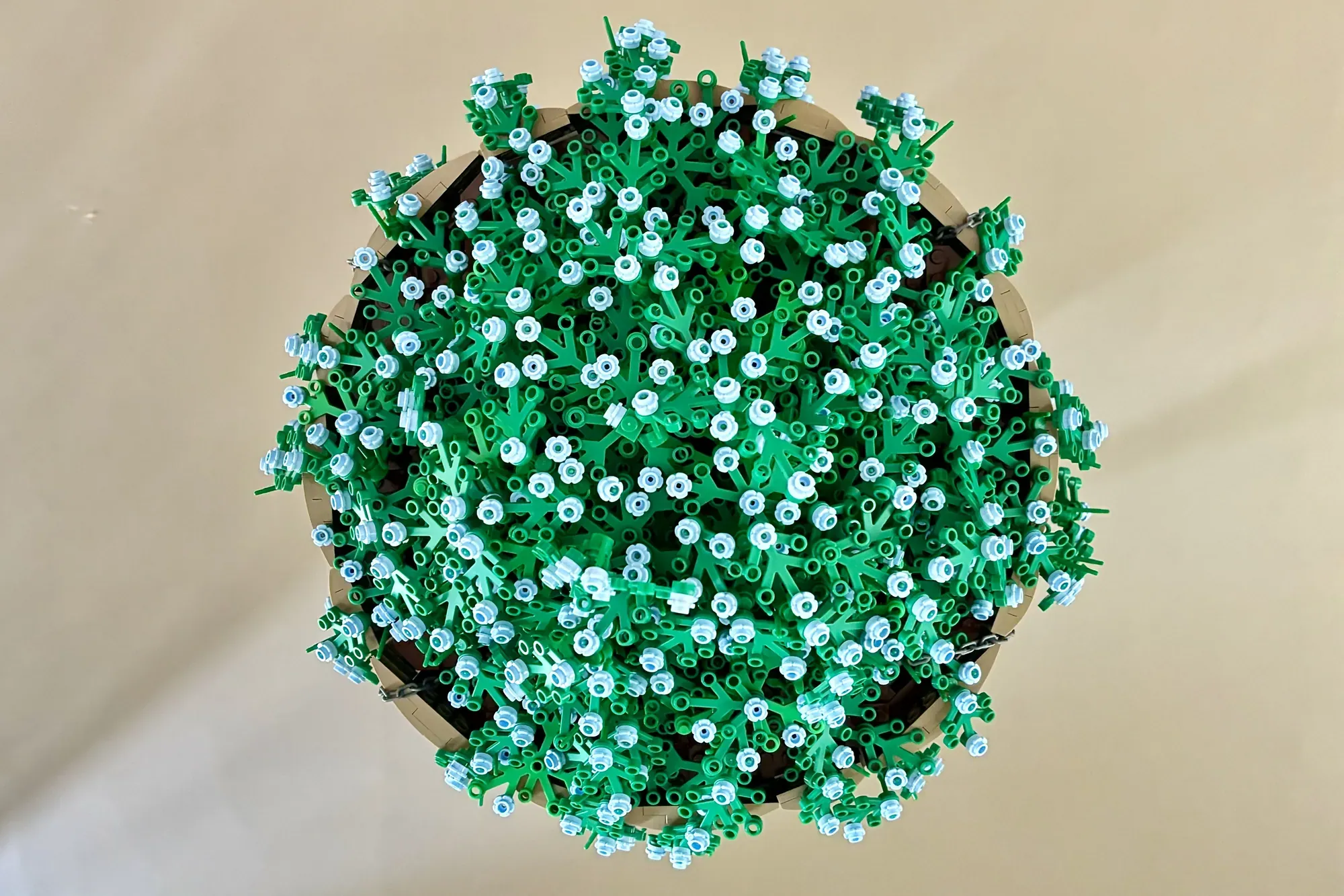LEGO hanging flower basket with white and green blooms suspended from tan brackets.