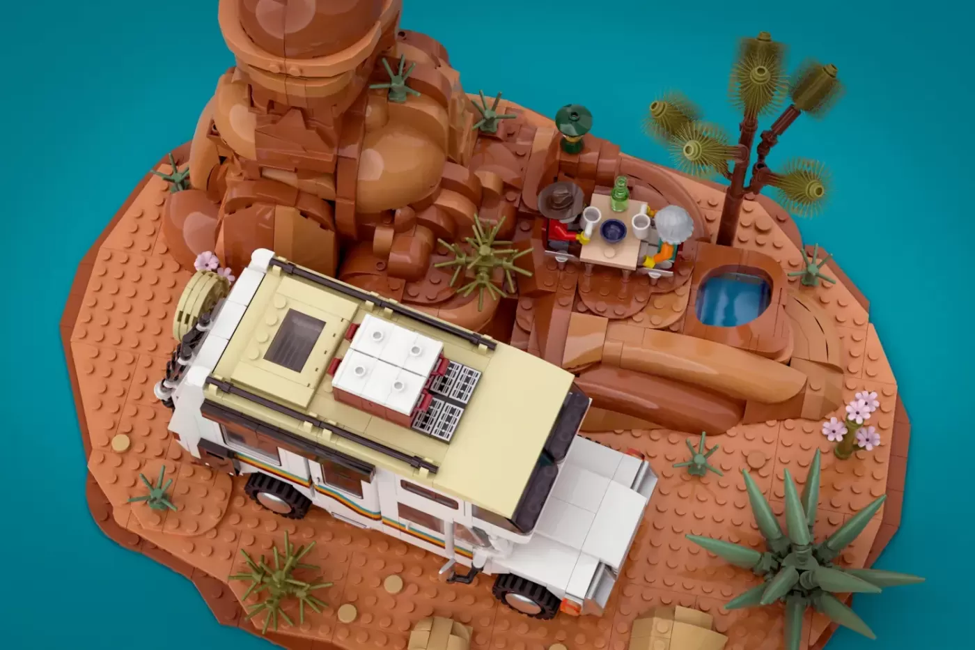 LEGO camper van with solar panels and kitchen on desert terrain with cacti and rock formations.
