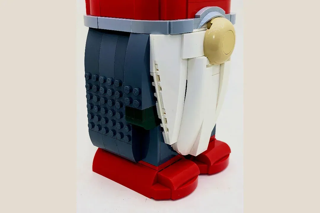 LEGO Christmas gnome with red hat, white beard, dark blue coat, gold buttons, and red feet.