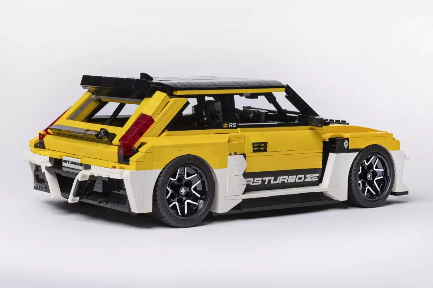 LEGO Renault 5 Turbo 3E model in yellow and white with open door and detailed wheels.