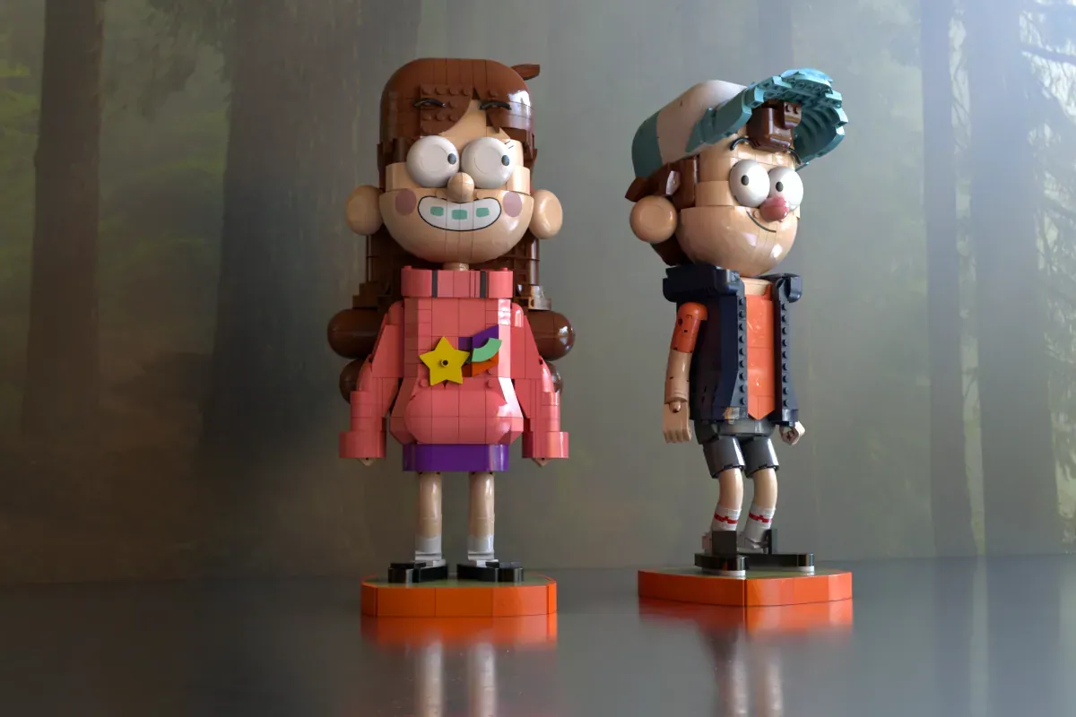 Two LEGO brick figures of Mabel and Dipper from Gravity Falls standing on orange bases against a misty forest backdrop.