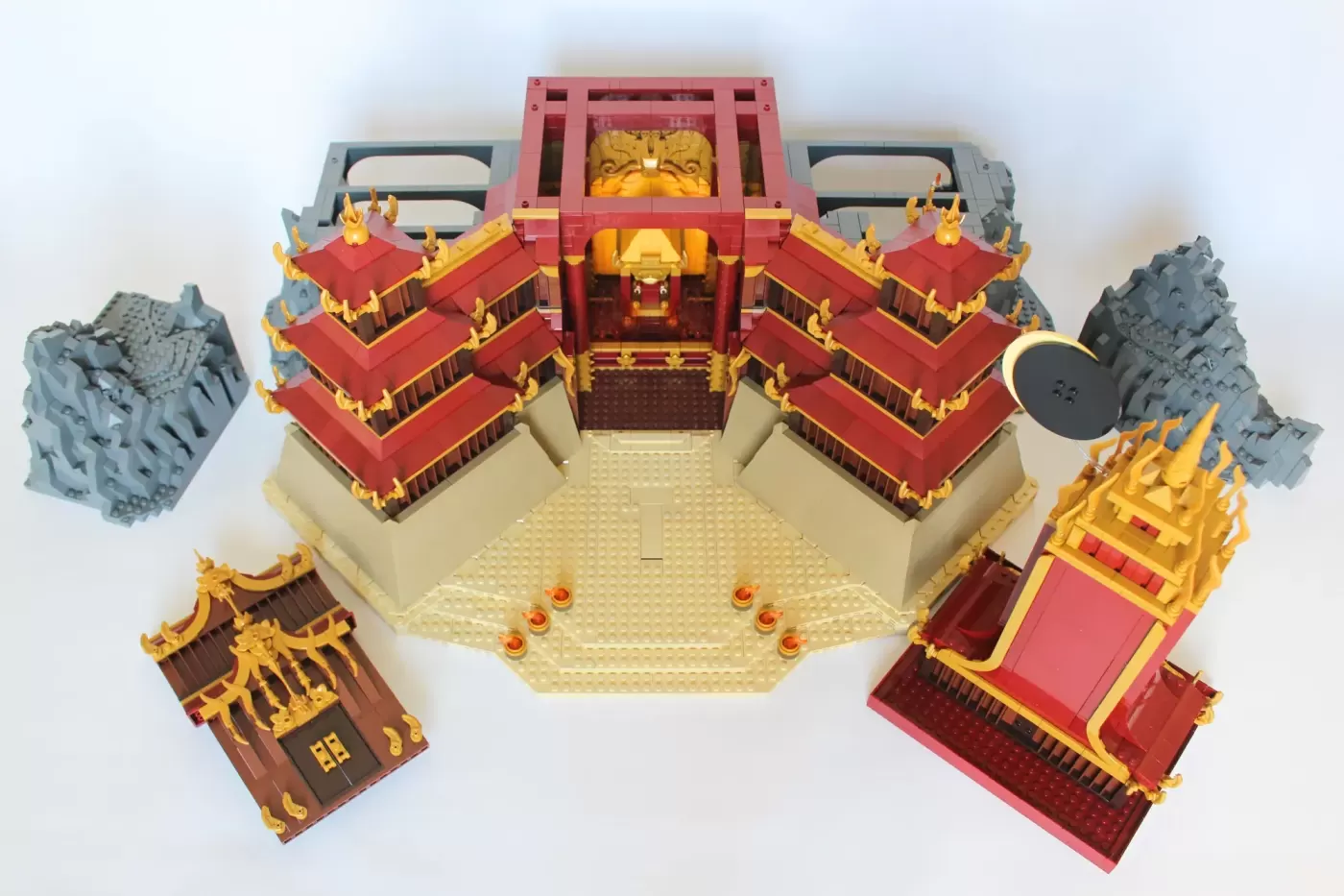 LEGO Fire Nation Palace set with red roofs, golden details, central courtyard, and rocky terrain pieces.
