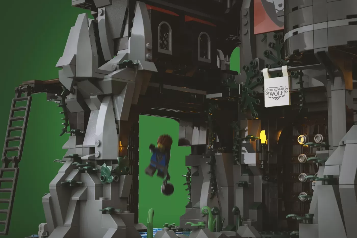 LEGO Wolfpack Fanghold castle set with minifigure on green screen during filming or photography shoot.